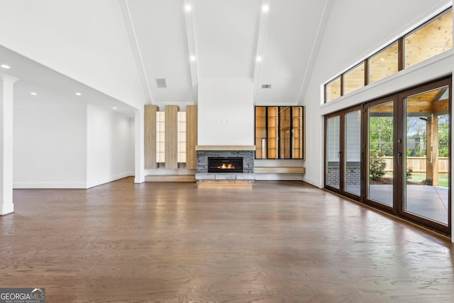 unfurnished living room featuring visible vents, high vaulted ceiling, baseboards, and a stone fireplace