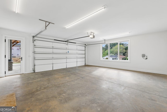 garage with a garage door opener and baseboards