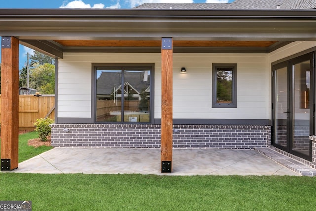 exterior space featuring fence and brick siding