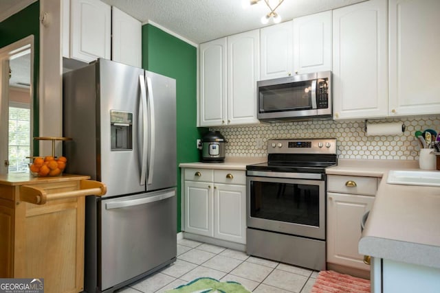 378 Beechwood Dr, Athens, GA 30606 - kitchen with white cabinetry, decorative backsplash, appliances with stainless steel finishes, and light tile patterned flooring