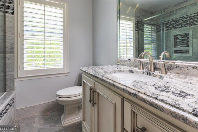 bathroom featuring toilet, vanity, and a stall shower