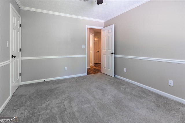 unfurnished bedroom featuring a ceiling fan, carpet floors, crown molding, and baseboards