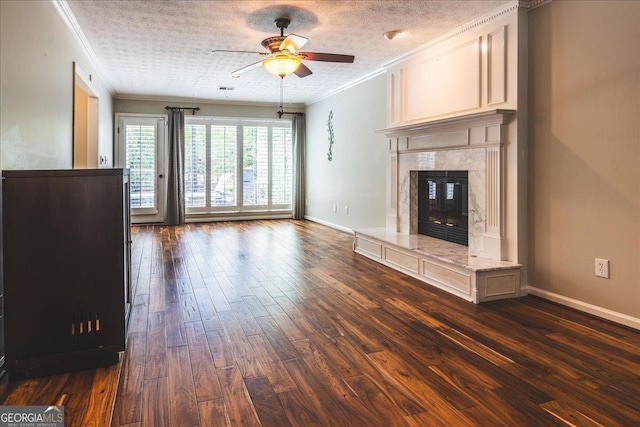 unfurnished living room with a ceiling fan, ornamental molding, dark wood-type flooring, baseboards, and a fireplace