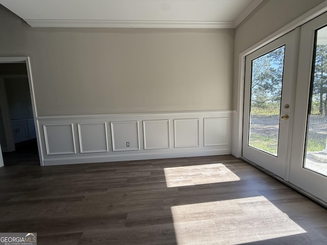 spare room with crown molding, wainscoting, french doors, and plenty of natural light