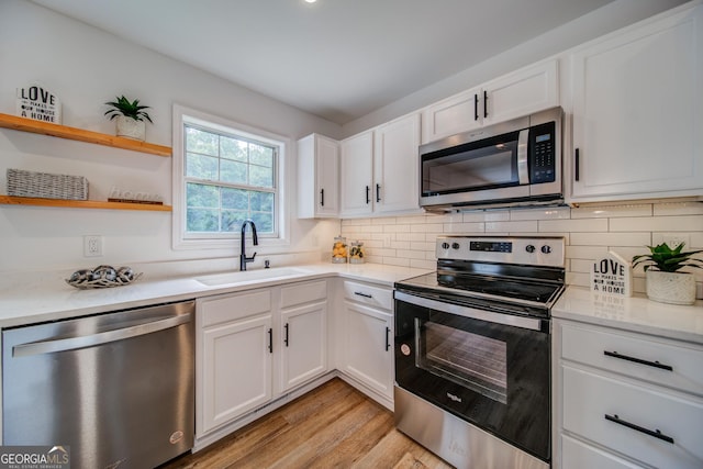 61 Meadowbrook Ln, Carrollton, GA 30117 - kitchen with appliances with stainless steel finishes, light wood finished floors, tasteful backsplash, and white cabinets