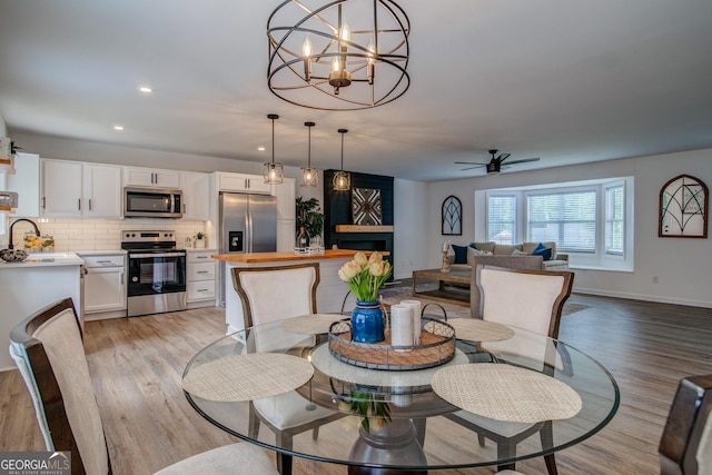 61 Meadowbrook Ln, Carrollton, GA 30117 - dining room featuring light wood-style floors, a ceiling fan, recessed lighting, and a chandelier