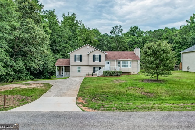 61 Meadowbrook Ln, Carrollton, GA 30117 - split level home featuring concrete driveway, a chimney, a porch, a front yard, and a forest view