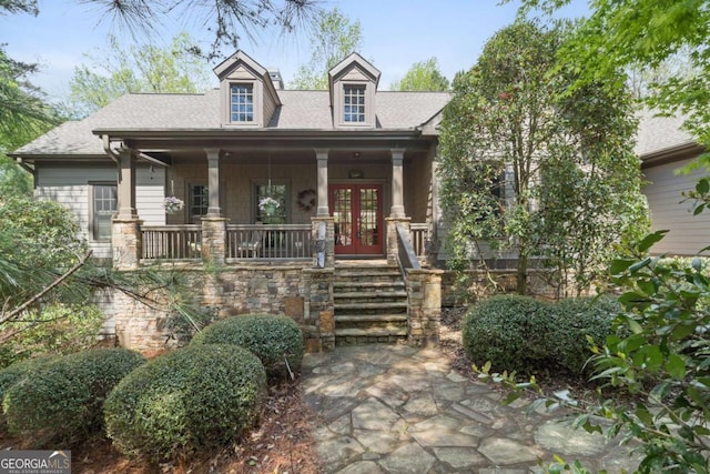view of front of home with french doors, a shingled roof, and stone siding