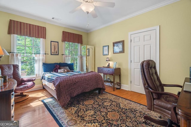 bedroom with visible vents, multiple windows, and wood finished floors