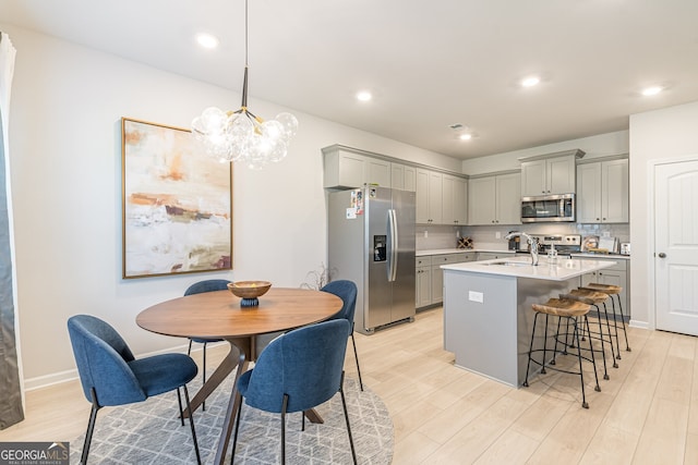 kitchen featuring gray cabinetry, light countertops, a sink, and appliances with stainless steel finishes