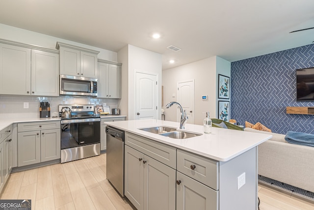 kitchen featuring gray cabinetry, appliances with stainless steel finishes, and a sink
