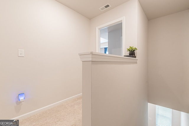 hall with carpet, visible vents, and baseboards