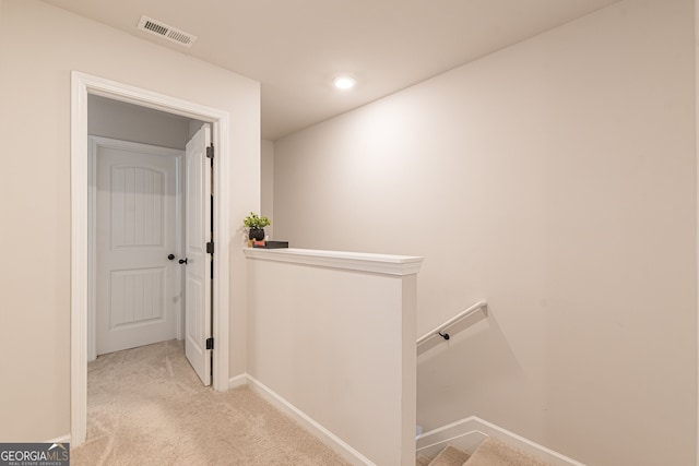 hall with visible vents, baseboards, an upstairs landing, carpet floors, and recessed lighting