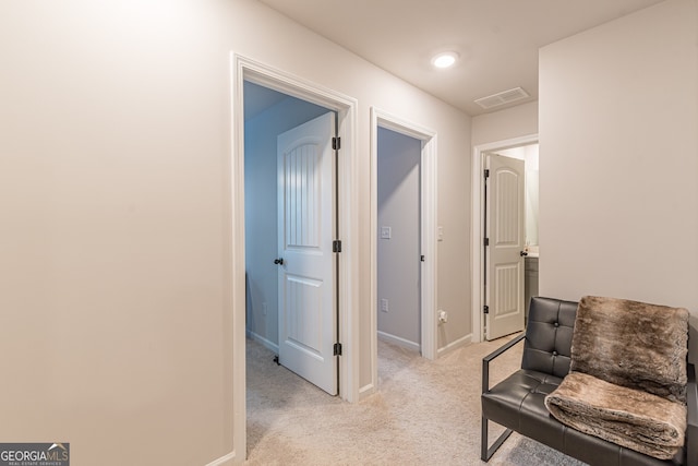interior space with visible vents, baseboards, and light carpet