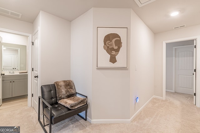 hall with light carpet, a sink, and visible vents