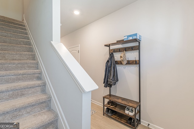 stairway featuring recessed lighting, baseboards, and wood finished floors