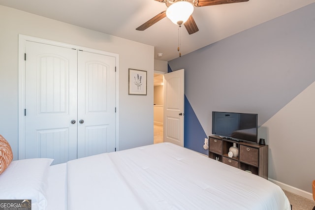 bedroom with a closet, baseboards, a ceiling fan, and carpet floors