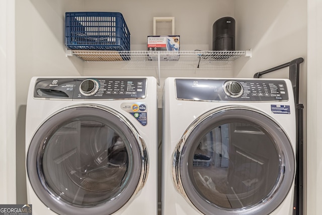 washroom with independent washer and dryer and laundry area