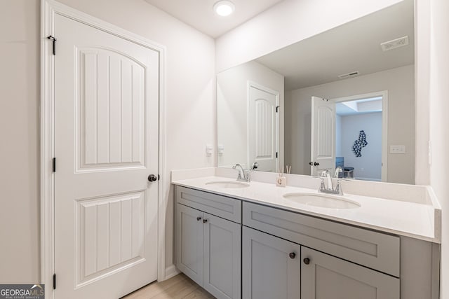 full bathroom with double vanity, visible vents, and a sink