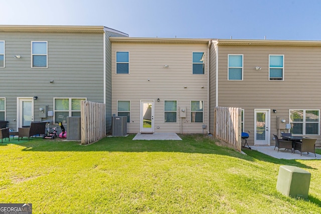rear view of house with a yard, a patio area, and central AC