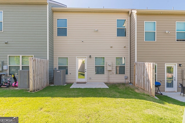 rear view of house with central air condition unit, a yard, a patio area, and fence