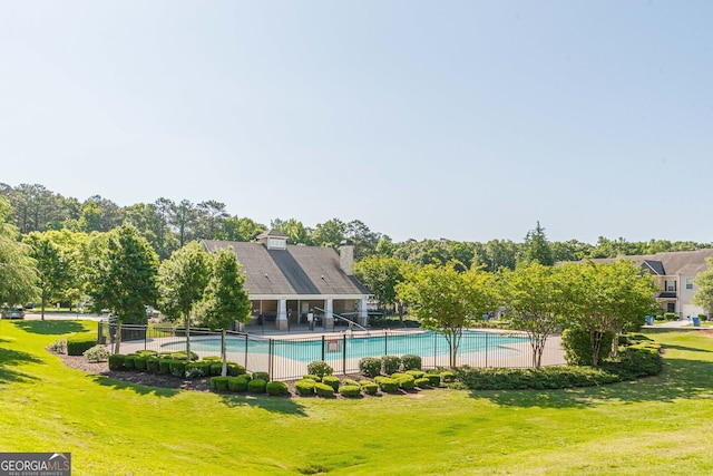 pool featuring a patio, a yard, and fence