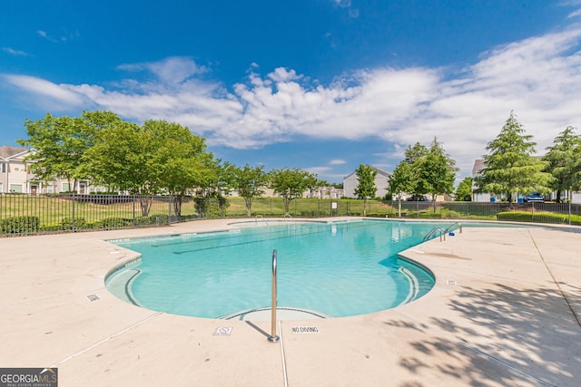 community pool with fence and a patio