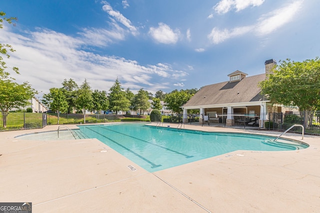 community pool featuring a patio and fence