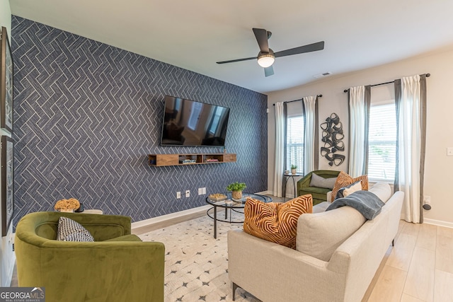 living room with visible vents, baseboards, ceiling fan, wood finished floors, and wallpapered walls