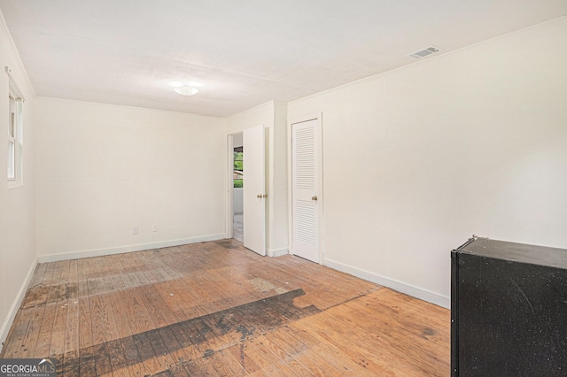 empty room with visible vents, baseboards, and hardwood / wood-style floors