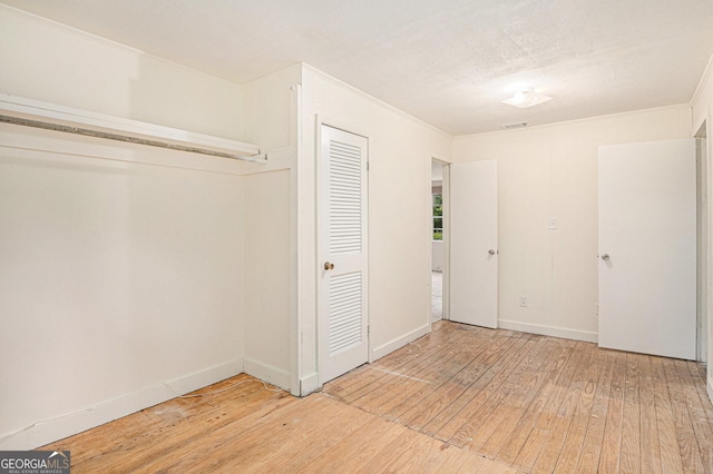 unfurnished bedroom with light wood finished floors, a closet, and baseboards