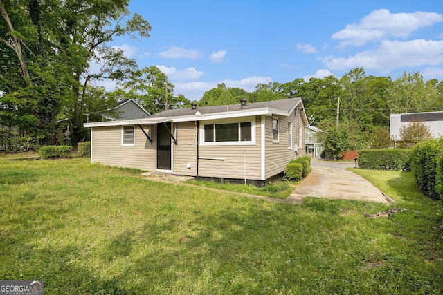 rear view of house featuring a yard