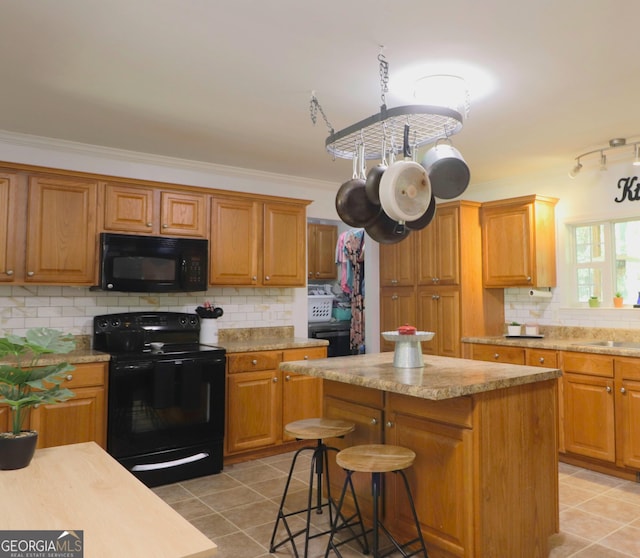 4650 Perry Rd, Gainesville, GA 30506 - kitchen featuring a breakfast bar, decorative backsplash, light tile patterned floors, a kitchen island, and black appliances