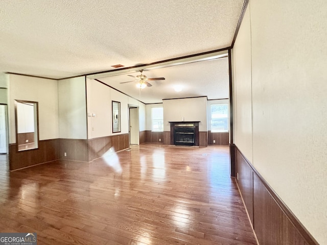 33 Keen Rd, Summerville, GA 30747 - unfurnished living room featuring hardwood / wood-style floors, a textured ceiling, ceiling fan, a wainscoted wall, and a fireplace