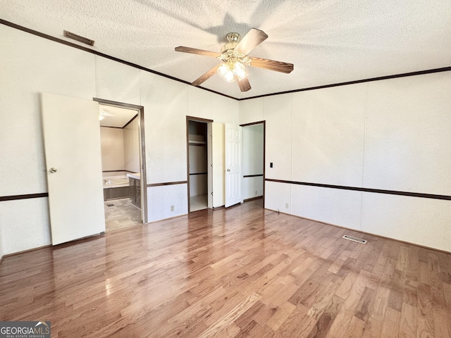 33 Keen Rd, Summerville, GA 30747 - unfurnished bedroom featuring ornamental molding, light wood-style flooring, a textured ceiling, connected bathroom, and a ceiling fan