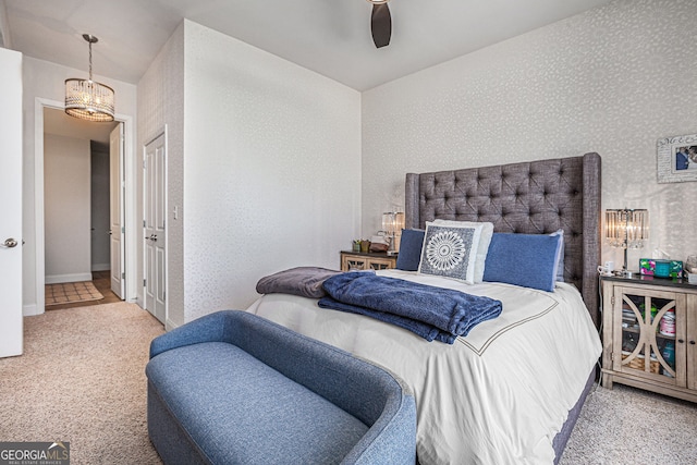 bedroom with baseboards, ceiling fan with notable chandelier, wallpapered walls, and carpet