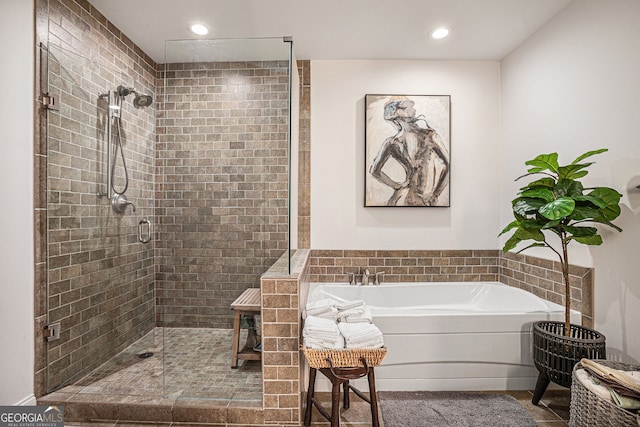 bathroom featuring recessed lighting, a bath, a shower stall, and tile patterned flooring