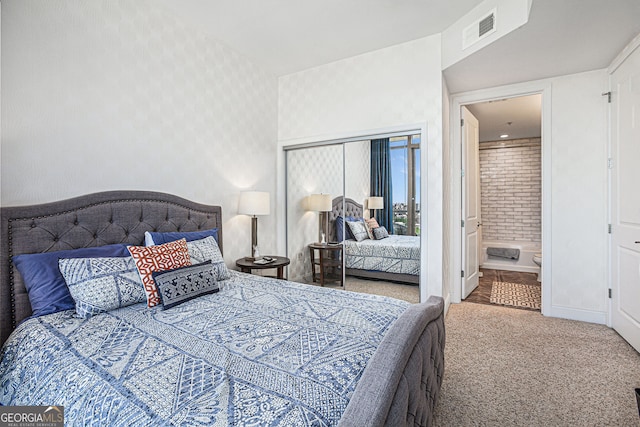 carpeted bedroom with ensuite bath, wallpapered walls, visible vents, and baseboards