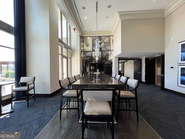 dining room with baseboards, a towering ceiling, and ornamental molding