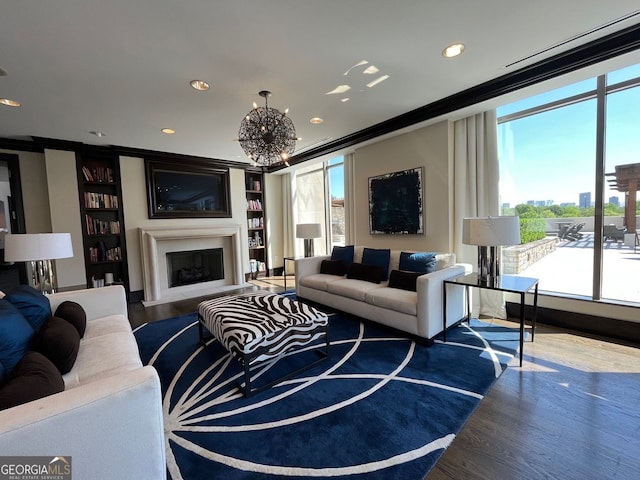 living room featuring a chandelier, wood finished floors, a healthy amount of sunlight, and recessed lighting
