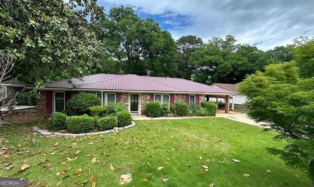 ranch-style home with a front lawn and metal roof