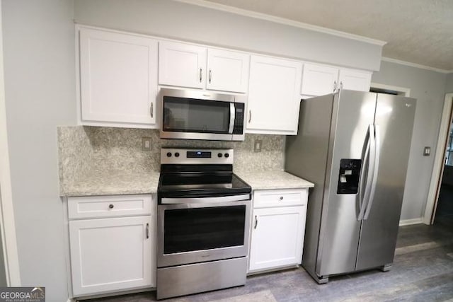 kitchen featuring stainless steel appliances, crown molding, white cabinets, decorative backsplash, and light wood-style floors
