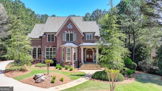 view of front of home with roof with shingles, french doors, a front lawn, a standing seam roof, and metal roof