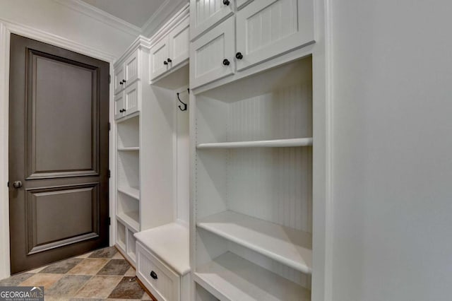 mudroom featuring stone finish floor and ornamental molding