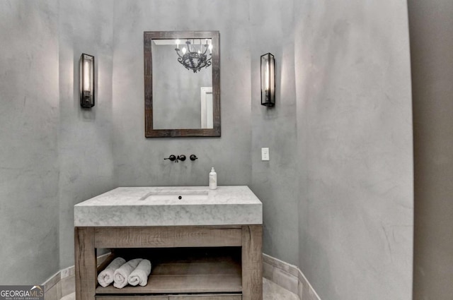 bathroom featuring a notable chandelier and a sink