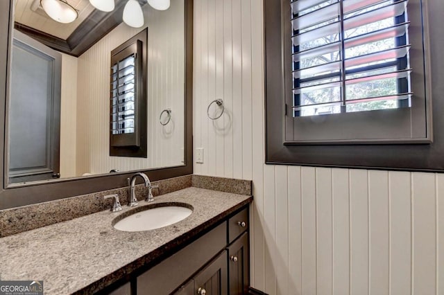 bathroom featuring wood walls and vanity