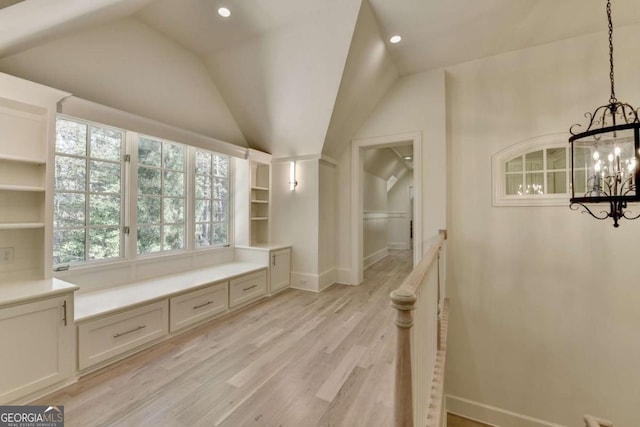 mudroom featuring light wood-style flooring, an inviting chandelier, baseboards, and vaulted ceiling