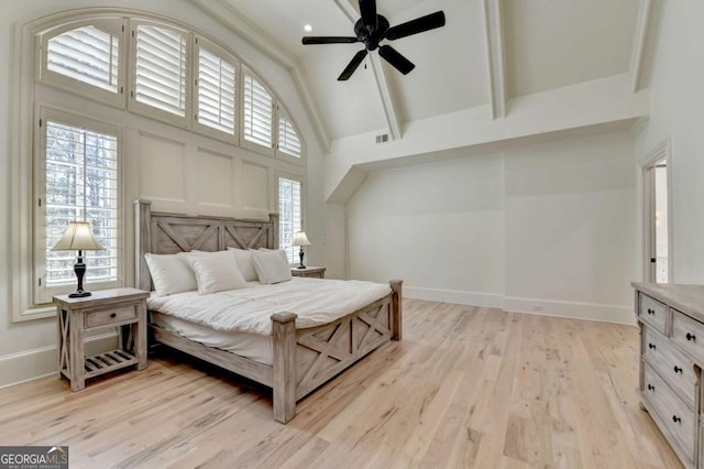 bedroom featuring high vaulted ceiling, multiple windows, and light wood-type flooring