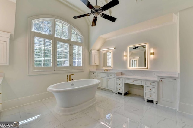 bathroom with a wealth of natural light, vanity, marble finish floor, and baseboards