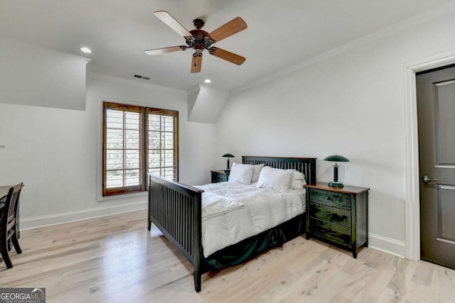 bedroom with light wood finished floors, visible vents, baseboards, and ornamental molding
